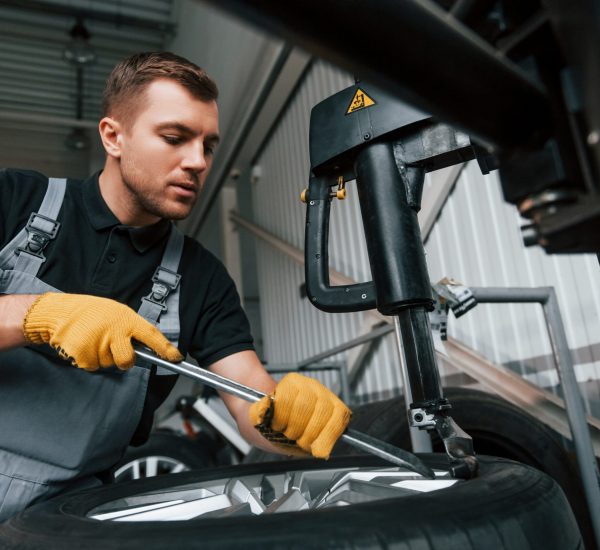 Employee at work. Man in uniform is in the auto service.